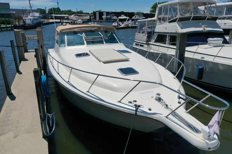 Slide: The Image of 1995 Tiara Yachts 4300 Open docked at marina, showcasing sleek design and spacious deck. - 4