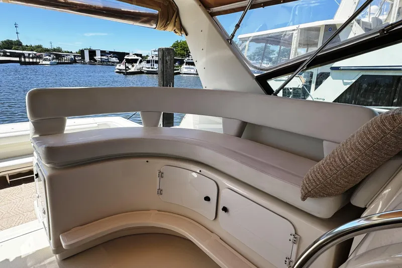 Slide: The Image of 1995 Tiara Yachts 4300 Open interior seating with waterfront view and storage compartments. - 10