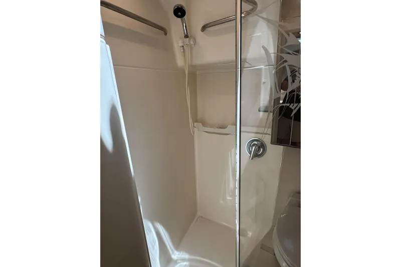 Slide: The Image of Shower area in 1995 Tiara Yachts 4300 Open, featuring glass door and chrome fixtures. - 28