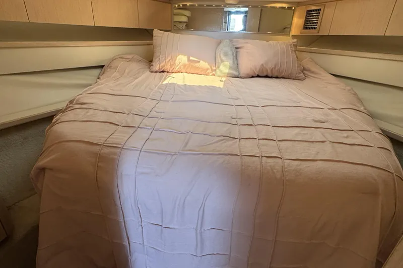 Slide: The Image of Cozy bedroom interior of 1995 Tiara Yachts 4300 Open with soft bedding and pillows. - 23