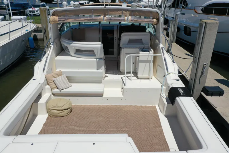 Slide: The Image of 1995 Tiara Yachts 4300 Open with spacious deck, seating, and cushions at marina. - 7