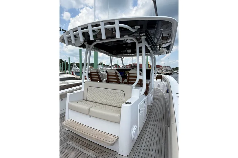 Slide: The Image of 2025 Jupiter 43 boat with cushioned seating and sleek design at a marina. - 37