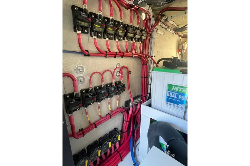 Slide: The Image of Electrical panel with red wiring and marine battery in a Jupiter 43, 2025 model. - 22