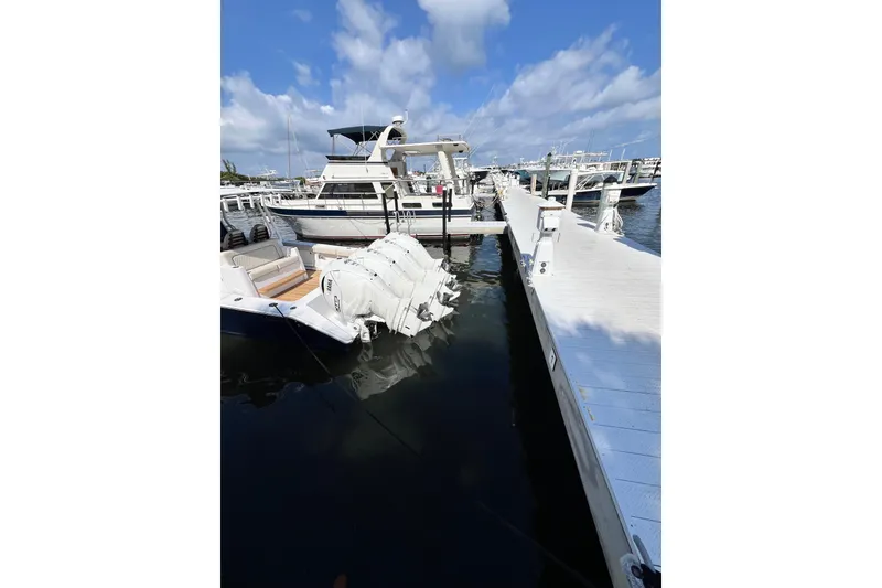 Slide: The Image of Docked 2025 Jupiter 43 boat with triple outboard engines under a clear blue sky. - 21