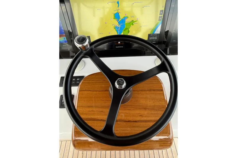 Slide: The Image of Steering wheel of 2025 Jupiter 43 boat with navigation display in background. - 35