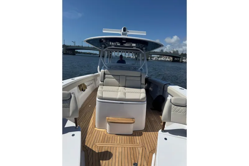 Slide: The Image of 2025 Jupiter 43 boat with sleek seating and wooden deck on a sunny day. - 6