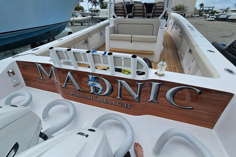 Slide: The Image of 2025 Jupiter 43 boat with "MADNIC" branding, docked at Palm Beach marina. - 5