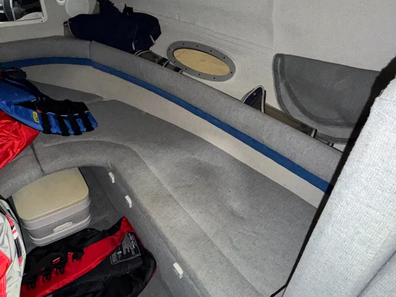 Slide: The Image of Interior of a 1992 Four Winns 225 Sundowner with gray upholstery and storage space. - 16