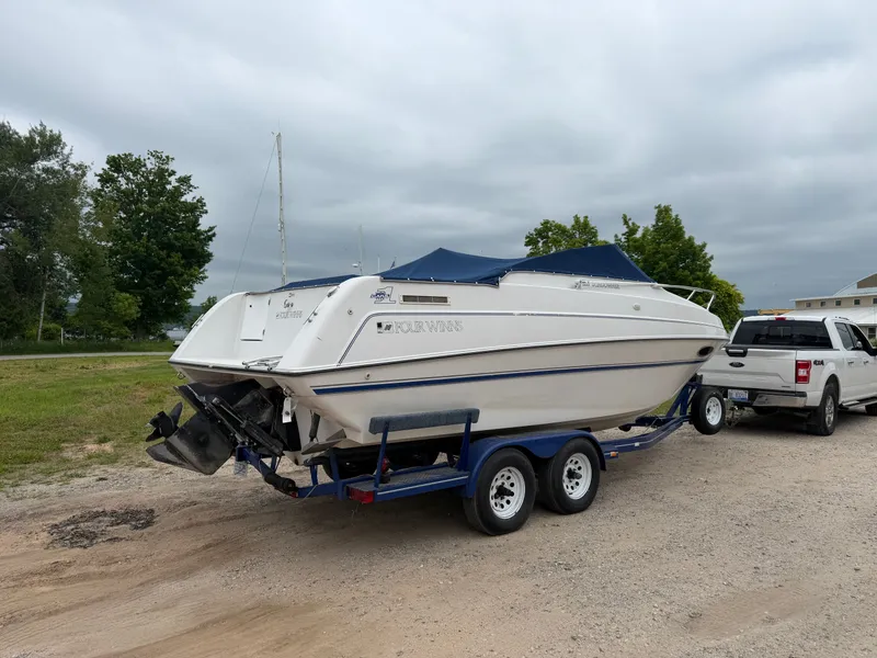 Slide: The Image of A white boat, a 1992 Four Winns 225 Sundowner, is on a trailer next to a pickup truck. - 3