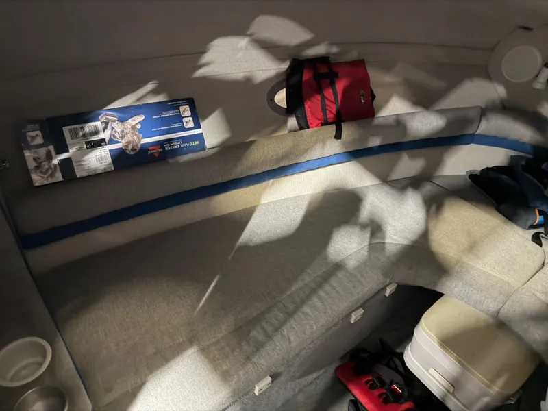 Slide: The Image of Interior of a 1992 Four Winns 225 Sundowner with seating and storage space. - 14