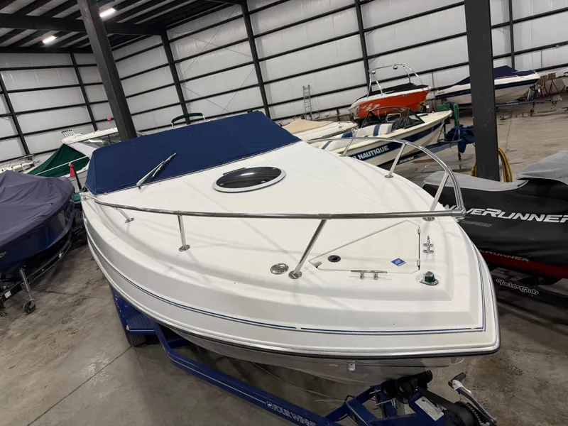 Slide: The Image of A 1992 Four Winns 225 Sundowner in a storage facility, placed on a trailer. - 7