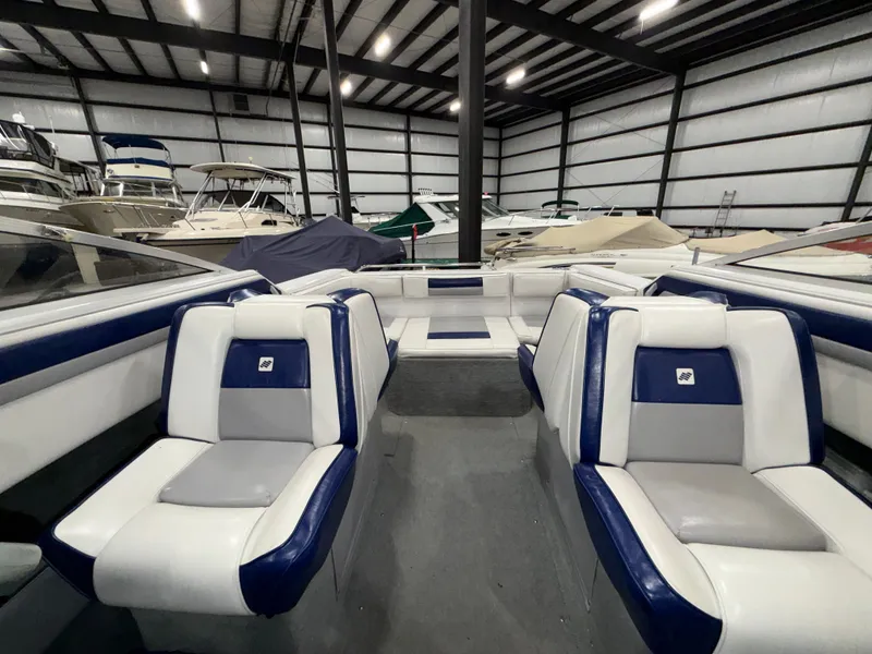 Slide: The Image of Interior of a 1992 Four Winns 225 Sundowner with blue and gray seating in a storage facility. - 10