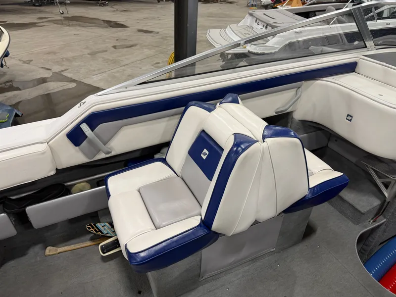 Slide: The Image of Interior of a 1992 Four Winns 225 Sundowner with blue and white seating. - 11