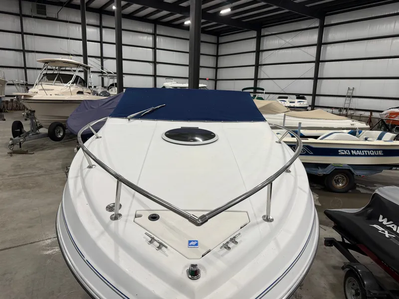 Slide: The Image of 1992 Four Winns 225 Sundowner in a warehouse with other boats. - 6