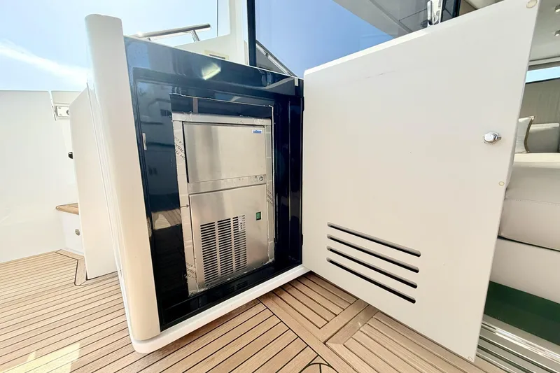 Slide: The Image of Azimut Fly 60 yacht 2021, featuring a built-in stainless steel appliance on teak flooring. - 69