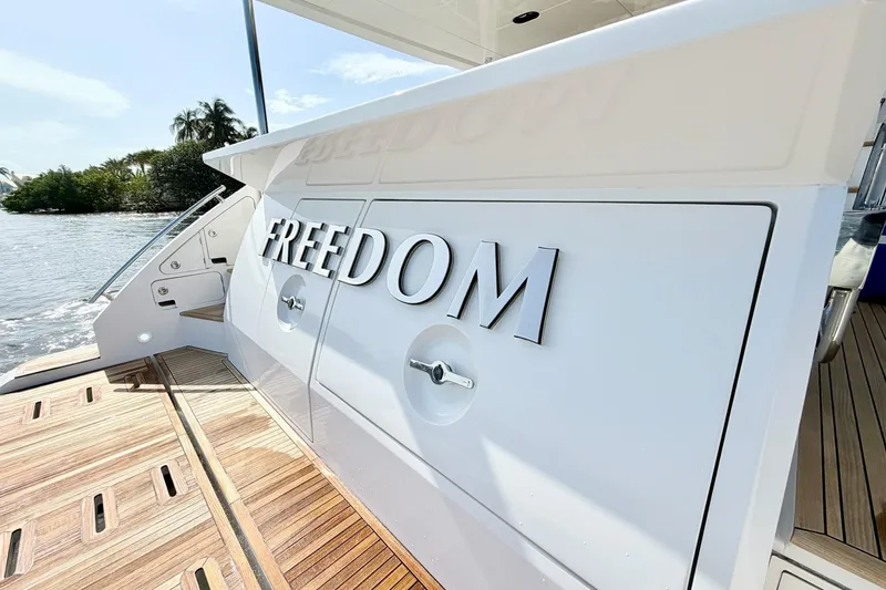 Slide: The Image of Azimut Fly 60 yacht, 2021 model, featuring "FREEDOM" on its sleek white exterior. - 63