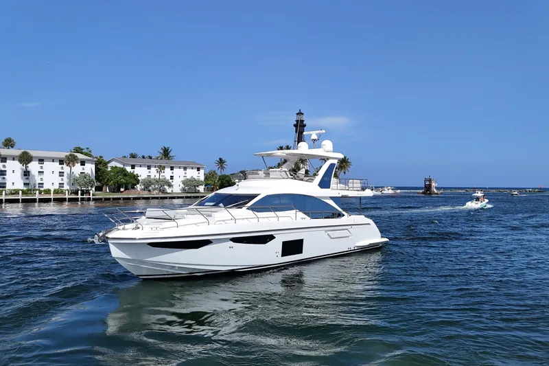 Slide: The Image of 2021 Azimut Fly 60 yacht cruising near coastal buildings and lighthouse. - 2