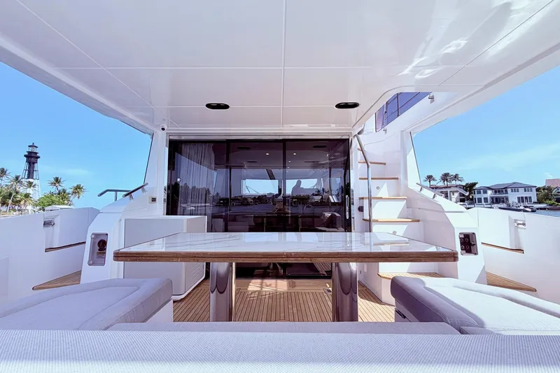 Slide: The Image of Luxurious 2021 Azimut Fly 60 yacht deck with elegant seating and scenic coastal view. - 12