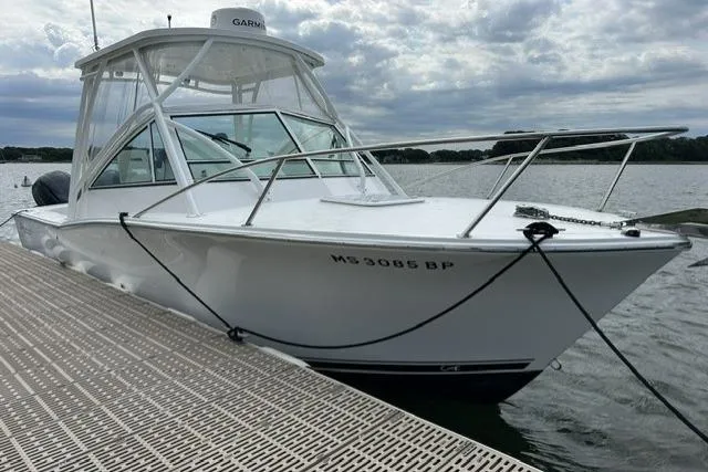 Slide: The Image of 2019 Albemarle 25 Express boat docked on a calm lake under cloudy skies. - 29