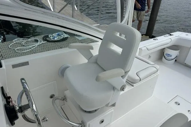 Slide: The Image of 2019 Albemarle 25 Express boat helm with white captain's chair and steering wheel. - 15