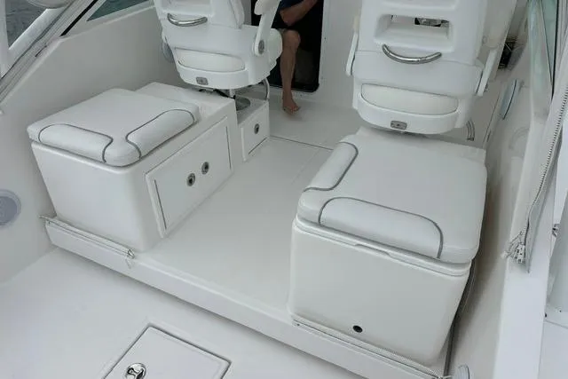 Slide: The Image of 2019 Albemarle 25 Express boat interior with white cushioned seating and storage compartments. - 19