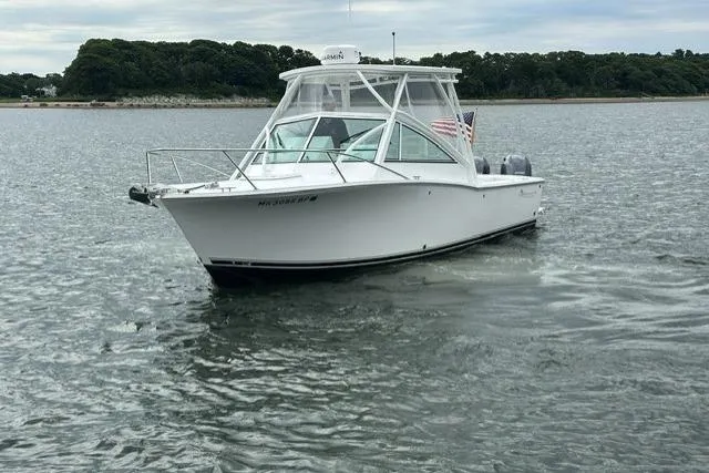 Slide: The Image of 2019 Albemarle 25 Express boat cruising on calm waters near a wooded shoreline. - 10