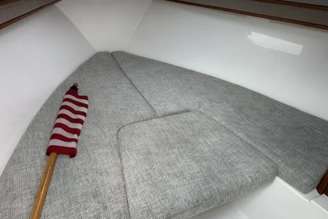 Slide: The Image of 2019 Albemarle 25 Express cabin interior with gray cushions and a small American flag. - 24