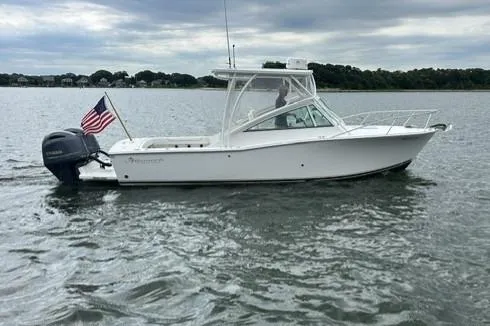 Slide: The Image of 2019 Albemarle 25 Express boat on water with American flag, overcast sky. - 4