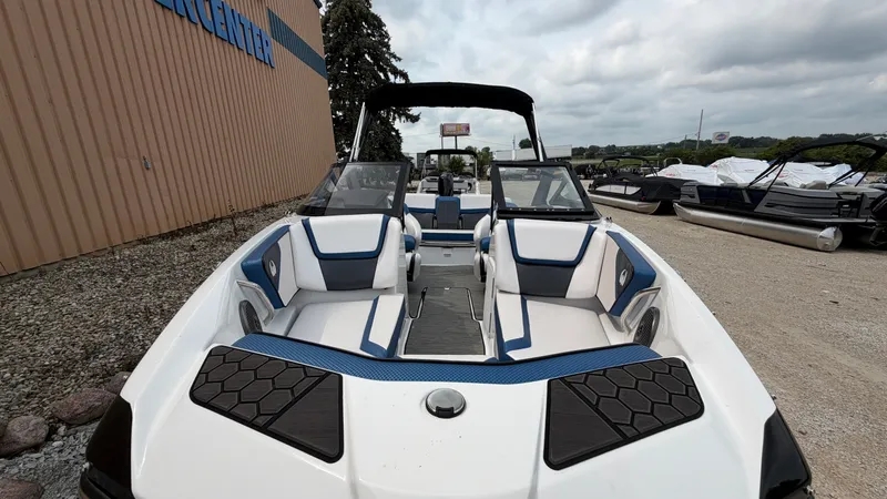 Slide: The Image of 2023 Scarab 195 ID with sleek design, blue accents, and comfortable seating, on a gravel lot. - 49