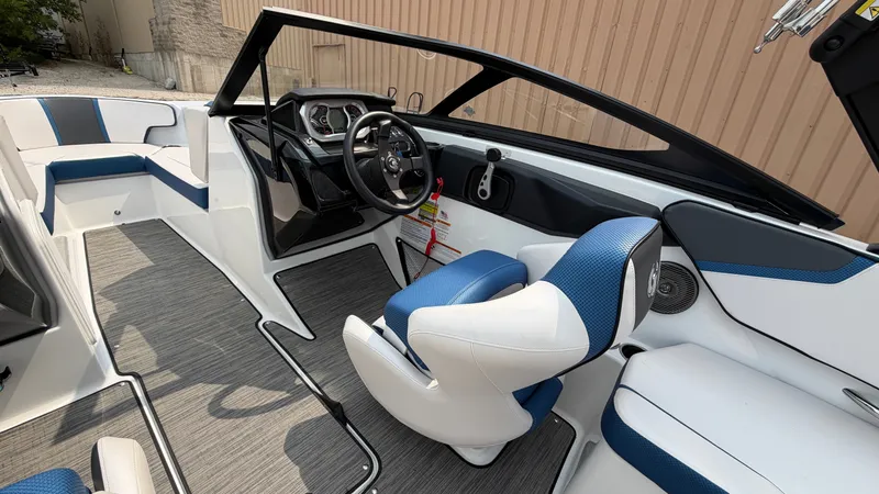 Slide: The Image of The image shows the cockpit of a 2023 Scarab 195 ID boat with modern blue and white seating. - 30