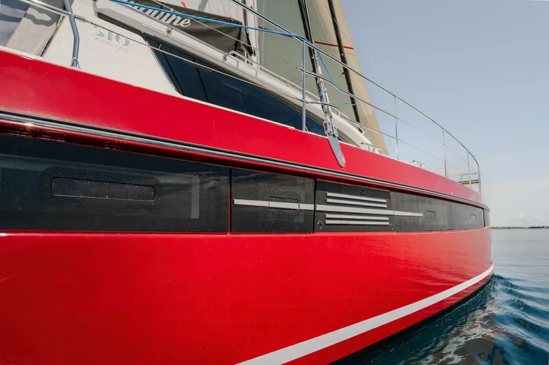 Slide: The Image of Red Privilege Signature 510 sailboat, 2025 model, on calm water. - 5