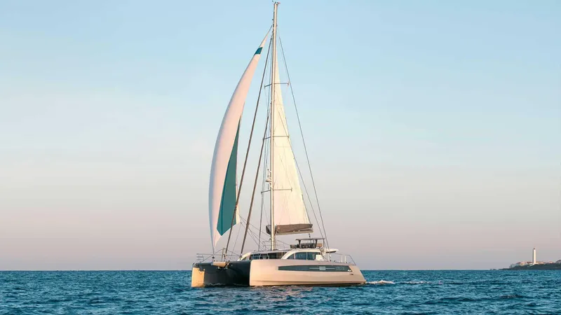 Slide: The Image of 2025 Privilege Signature 580 catamaran sailing on calm ocean waters. - 2