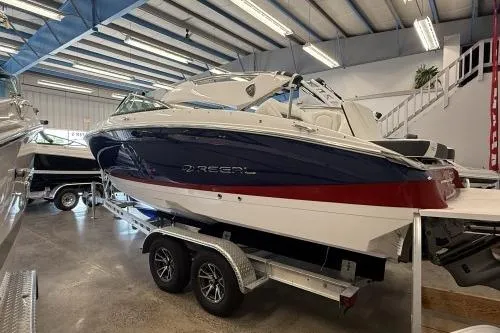 The Image of 2027 Regal LS4 boat in showroom, featuring sleek design and dual-axle trailer. - 1