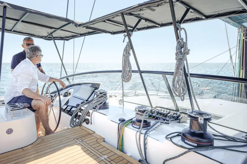 Slide: The Image of Two people navigating a 2025 Privilege Signature 650 yacht on open water. - 16