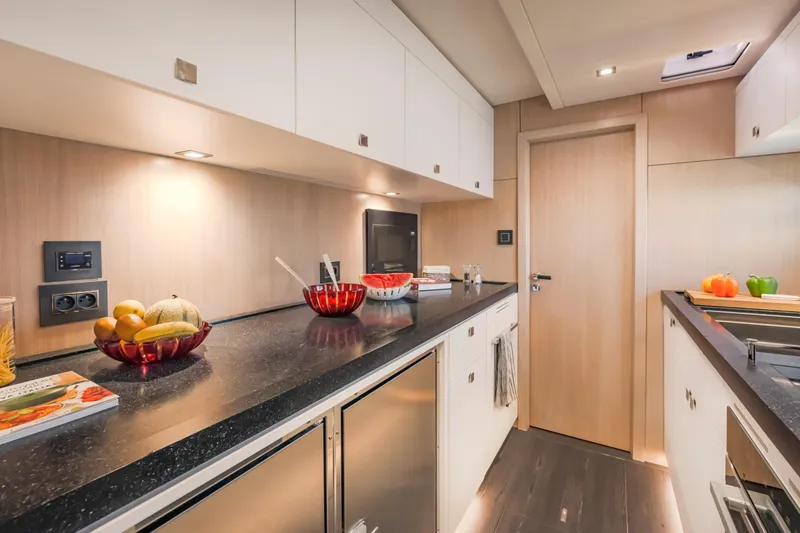 Slide: The Image of Modern kitchen interior on 2025 Privilege Signature 650 yacht, featuring sleek countertops and cabinetry. - 34