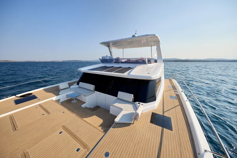 Slide: The Image of Modern Omaya 50 Power Catamaran 2025 on open sea, featuring spacious deck and sleek design. - 16