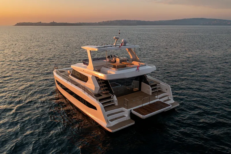 Slide: The Image of 2025 Custom Omaya 50 Power Catamaran at sunset on calm waters. - 8