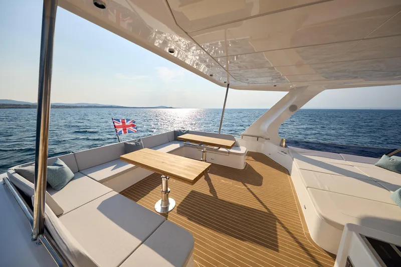Slide: The Image of Luxurious 2025 Omaya 50 Power Catamaran deck with seating, tables, and ocean view. - 38
