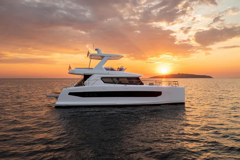 Slide: The Image of 2025 Custom Omaya 50 Power Catamaran at sunset on the ocean. - 2