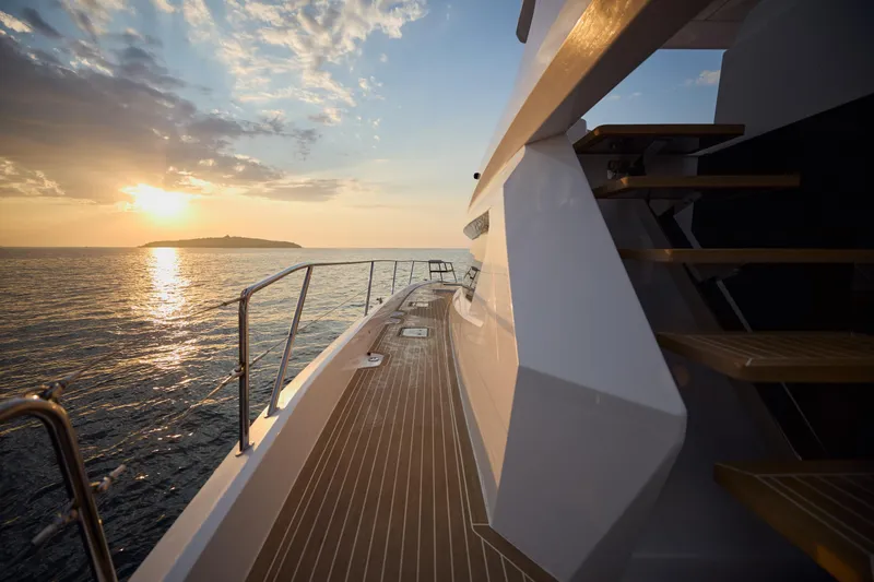 Slide: The Image of 2025 Omaya 50 Power Catamaran deck at sunset, ocean view. - 12