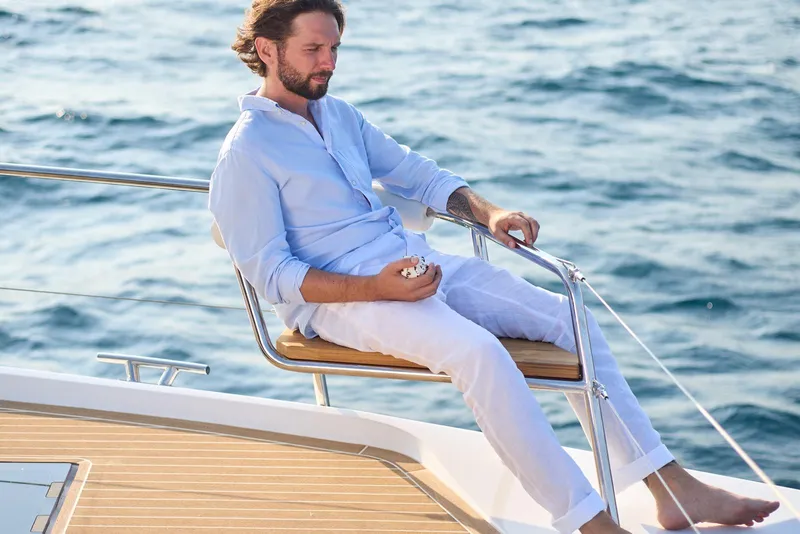 Slide: The Image of Man relaxing on 2025 Omaya 50 Power Catamaran, enjoying ocean view. - 25