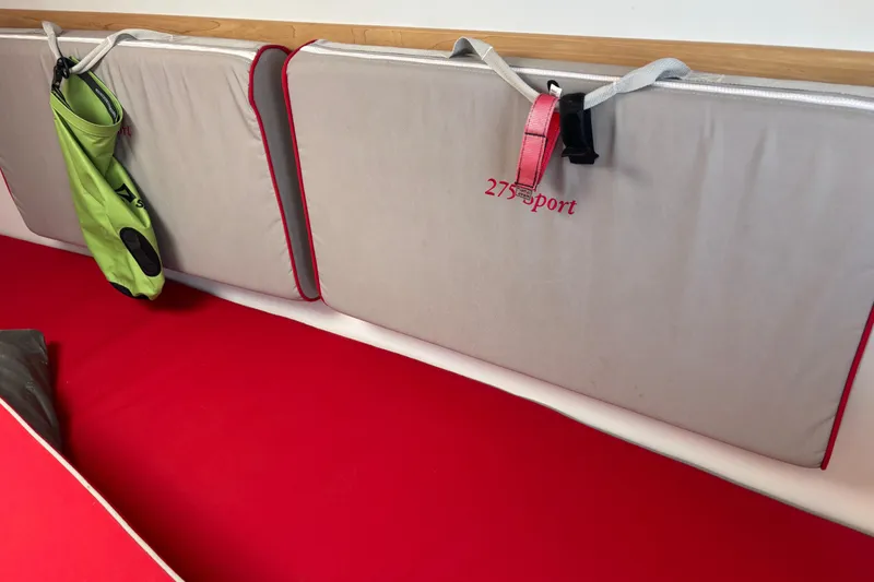Slide: The Image of Interior of 2015 Catalina 275 Sport with red cushions and storage bag. - 24