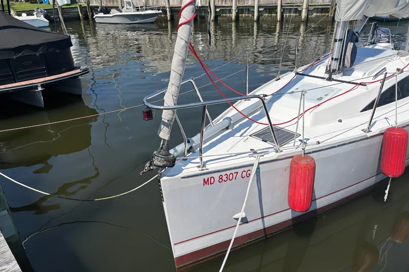Slide: The Image of 2015 Catalina 275 Sport sailboat docked with red fenders, reflecting on calm water. - 2