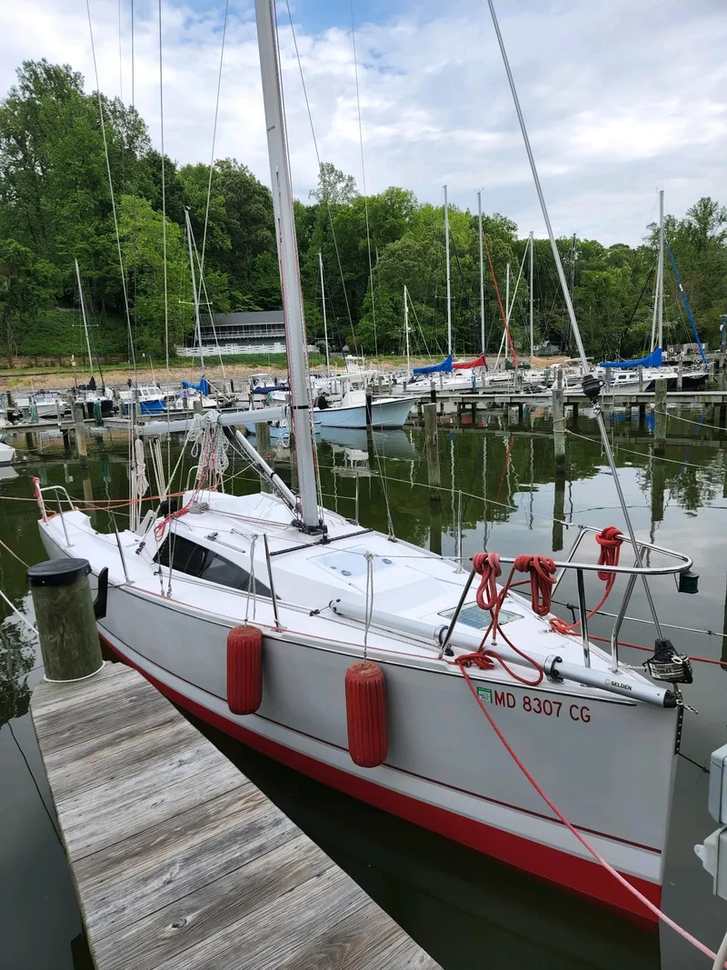 Slide: The Image of A white sailboat docked at a wooden pier in a calm marina. - 10