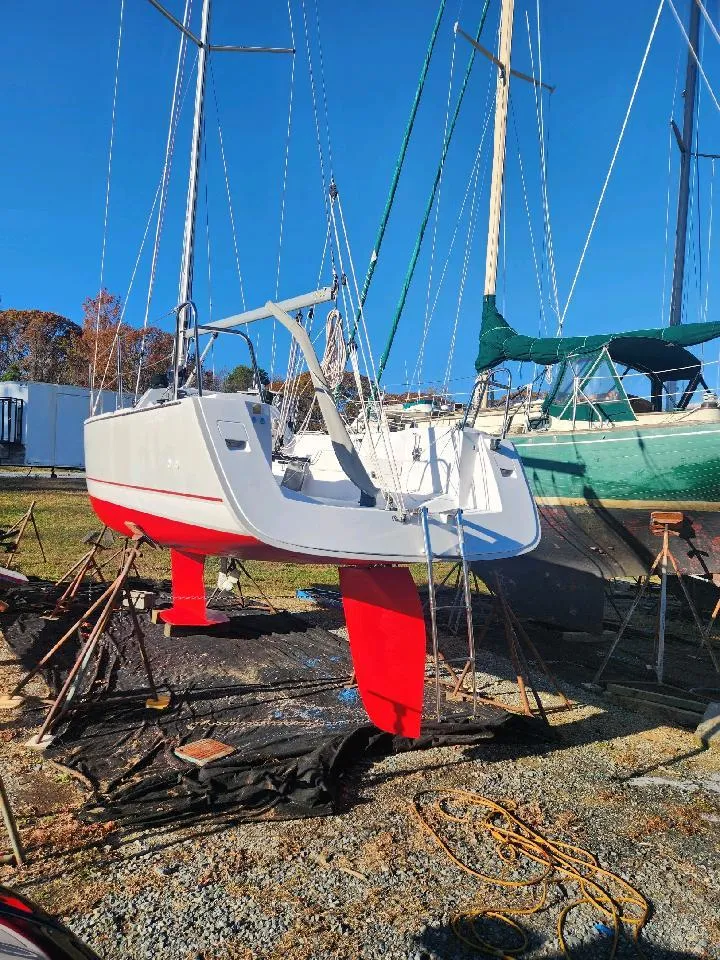 Slide: The Image of A 2015 Catalina 275 Sport is on a dry dock. The hull is white with red accents. - 7