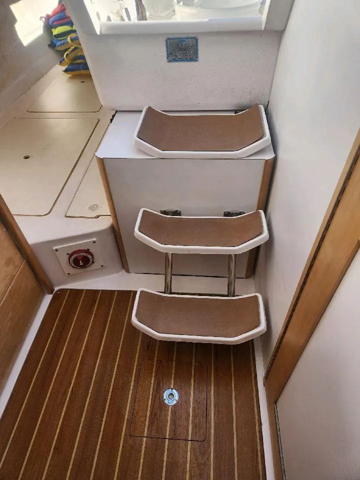 Slide: The Image of Interior of a Catalina 275 Sport with wooden steps and storage area. - 27