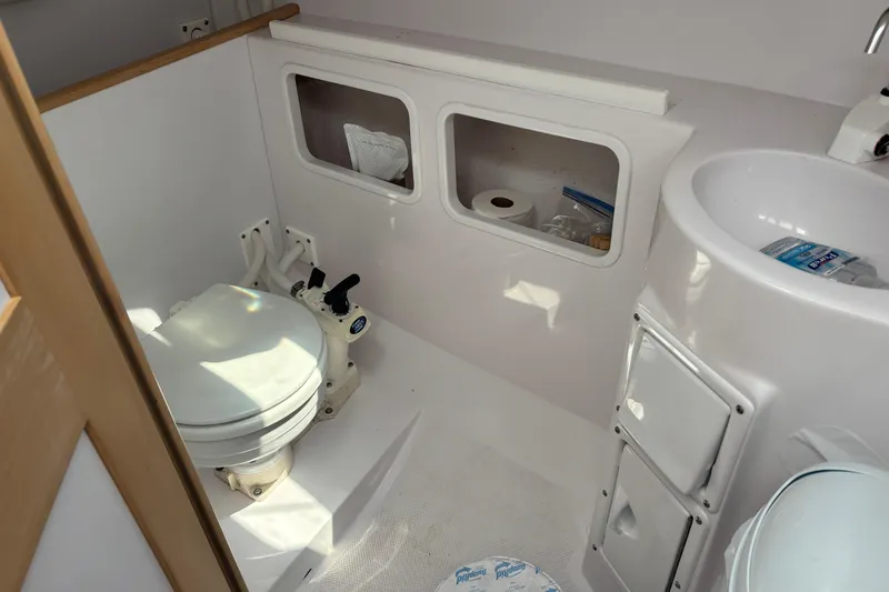 Slide: The Image of 2015 Catalina 275 Sport boat bathroom with toilet, sink, and storage compartments. - 18