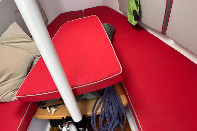 Slide: The Image of Interior of a 2015 Catalina 275 Sport sailboat with red cushions and storage space. - 4