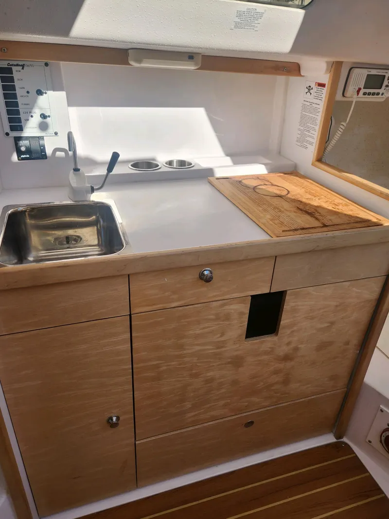 Slide: The Image of Interior view of a 2015 Catalina 275 Sport featuring a small kitchenette. - 22