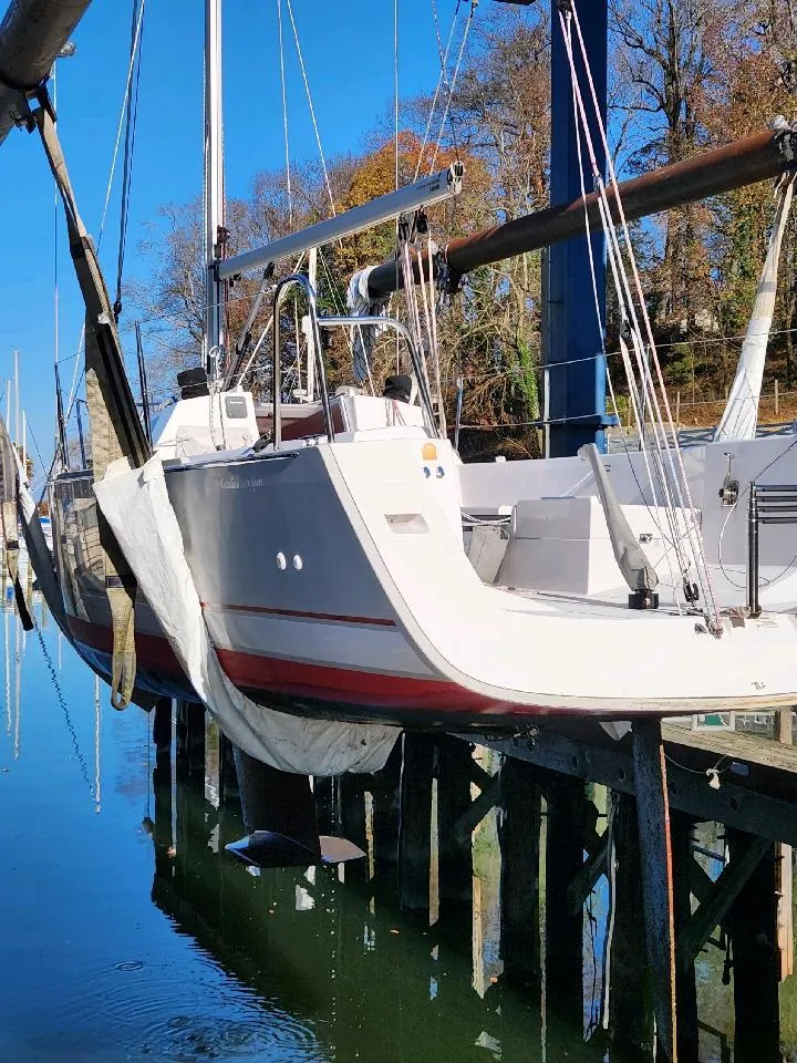 Slide: The Image of A white sailboat with a red stripe is suspended at a dock. - 15
